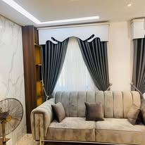 Dark curtain styling with a tufted grey sofa