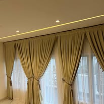Olive-gold curtains with ceiling cove lighting