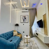 Living room styled with a tufted blue sofa and warm accents
