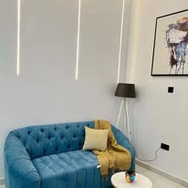 Living room with statement pendant lighting and blue sofa