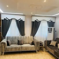 Living room styled with tailored curtains and striped blinds